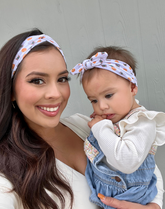 Mom and daughter are wearing matching mommy and me headbands from By Bella Boutique.